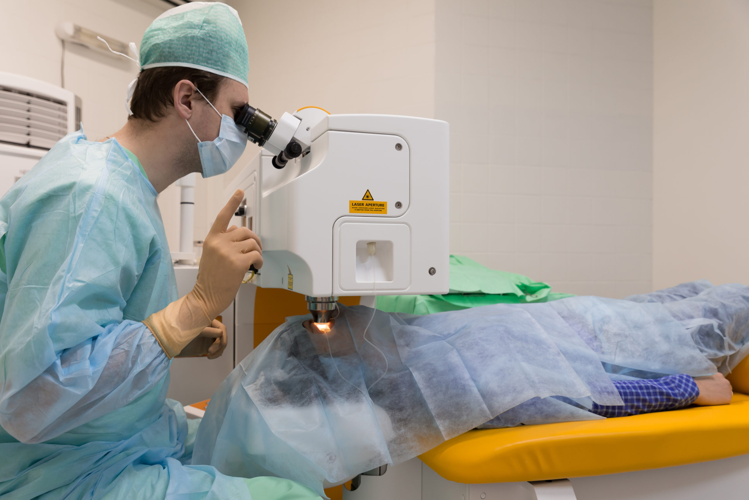 Chirurgien de la basse vision opérant un patient en se servant d'une machine à fort grossissement