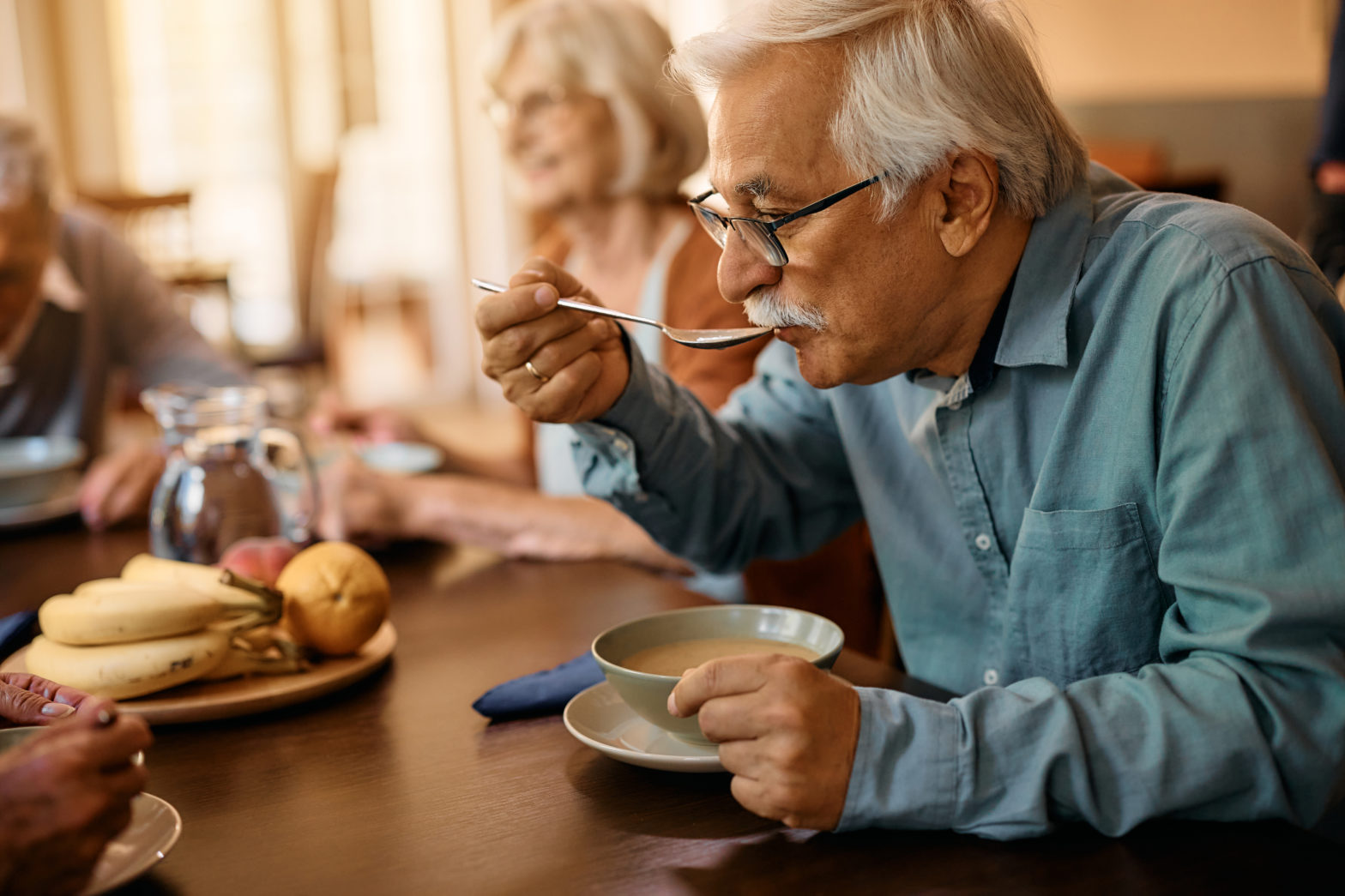 Personne âgée mangeant une soupe dans un cadre chaleureux